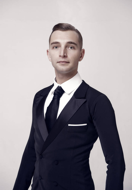 Ballroom dancer in stylish tuxedo. Man in elegant suit with tie. Groom dressed for wedding or holiday celebration. Dress code for businessman. Fashion style and trend concept - Foto, Bild
