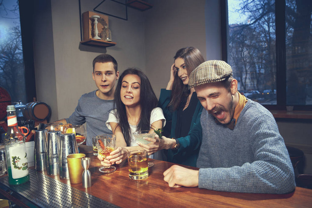 Photo of joyful friends in the bar communicating with each other - Valokuva, kuva