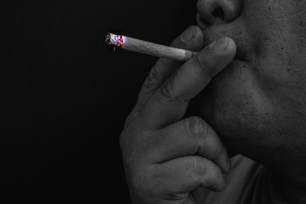 Mies tupakoi savuketta, Kuva savukkeen kädessä savun kanssa
 - Valokuva, kuva