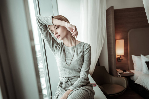 Elegant woman wearing grey dress and accessories having rest - Foto, afbeelding