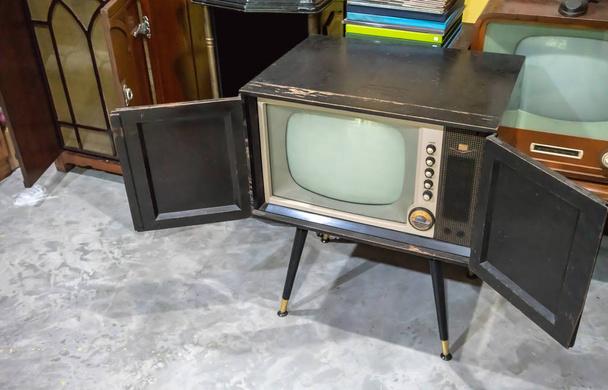 Vintage oude televisie op betonnen vloer in de oude kamer - Foto, afbeelding