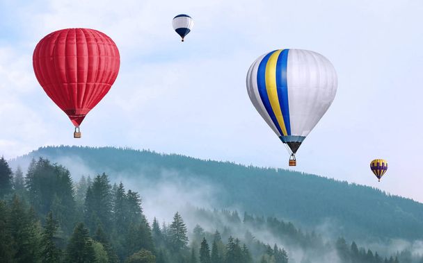 Mountain landscape and flying air balloons over green forest - Foto, afbeelding