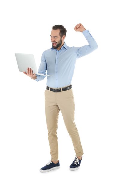 Συναισθηματική νεαρός άνδρας με το laptop που γιορτάζει τη νίκη σε λευκό φόντο - Φωτογραφία, εικόνα