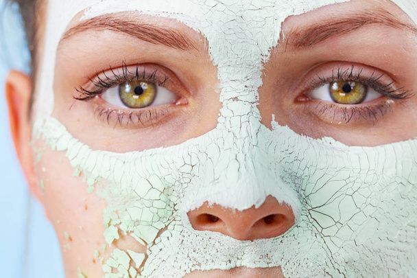 Close up woman with green mud mask on face, detail view. Teen girl have dry cracked cosmetic on skin. Beauty treatment. Skincare. - Foto, immagini
