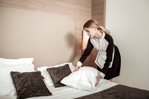 Professional housekeeper putting clean white pillow on bed - Fotografie, Obrázek