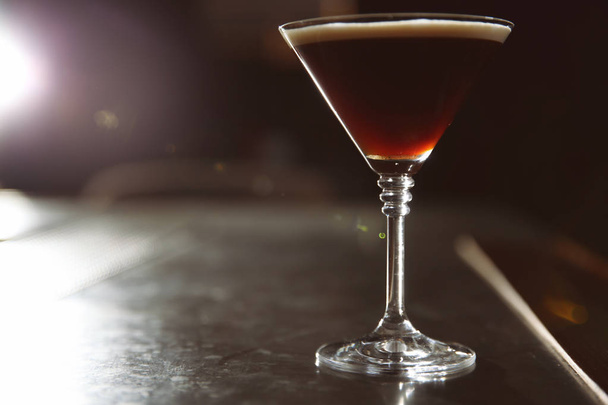 Glass of martini espresso cocktail on bar counter. Space for text - Zdjęcie, obraz
