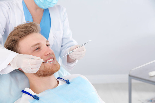 Dentist examining patient's teeth in modern clinic. Space for text - Φωτογραφία, εικόνα