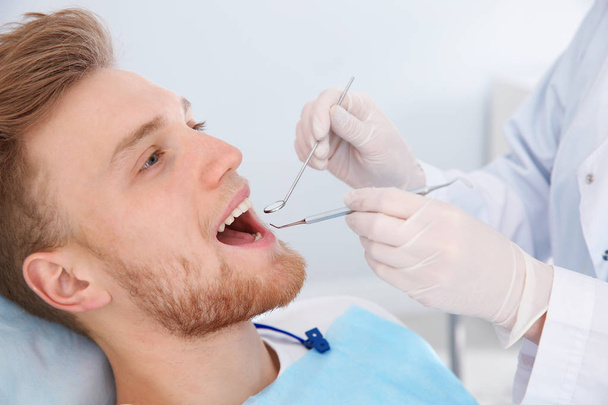 Dentist examining patient's teeth in modern clinic - Foto, imagen