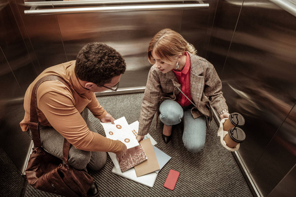 Inattentive woman dropping documents on the floor in elevator - Foto, Imagem