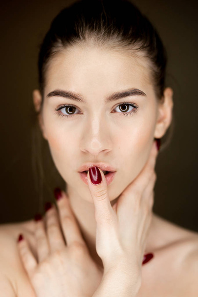 Portrait of young charming girl with natural makeup holding her hands on her face - Фото, изображение
