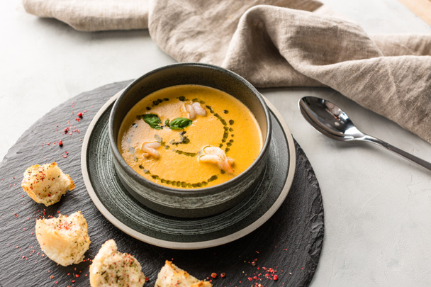 Тыквенный суп с креветками, гренки, каменный фон, вегетарианское блюдо, меню ресторана
 - Фото, изображение