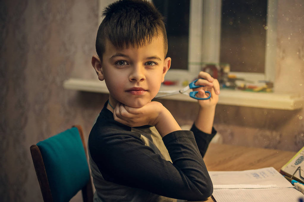 Jonge jongen zitten aan de tafel zijn school huiswerk - Foto, afbeelding