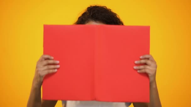 Smart biracial female millennial shocked with scientific facts, holding red book - Filmmaterial, Video