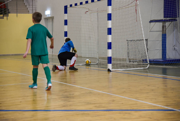Athlete teenager scored a goal by a goalkeeper while playing mini football in the gym - Photo, Image