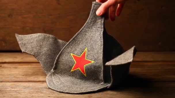 Μαλλί καπέλο χέρι κόκκινο σύμβολο αστέρι ξύλινο γραφείο βίντεο hd  - Πλάνα, βίντεο