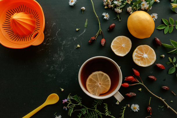 Rozenbottels kruiden thee plat leggen bovenaanzicht met schijfje citroen op houten tafel - Foto, afbeelding