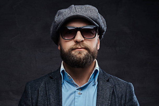 Close-up portrait of a successful stylish man in sunglasses wearing a beret and jacket, isolated on white background - Photo, Image