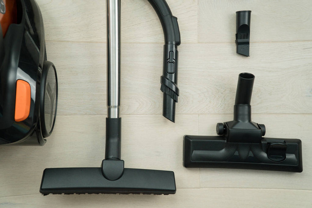 Vacuum cleaner on the wooden floor. Black vacuum cleaner brush closeup - Photo, Image