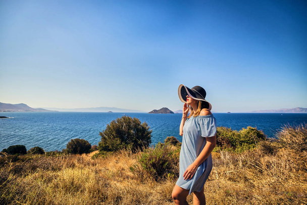 schöne Frau mit Strandhut genießt Meerblick mit blauem Himmel bei sonnigem Tag in Bodrum, Türkei. Urlaub im Freien Seenlandschaft Sommerreisekonzept - Foto, Bild