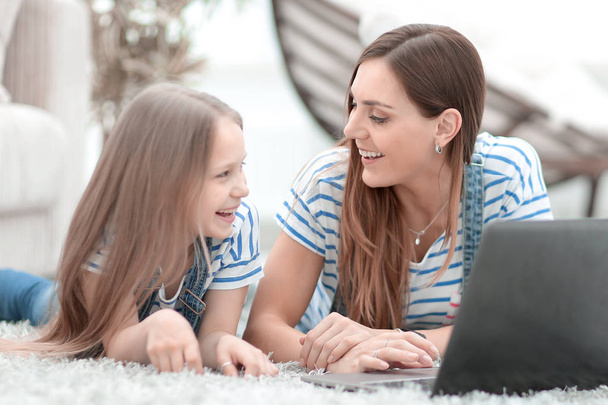 mom and her little daughter using a laptop in their free time - Foto, imagen