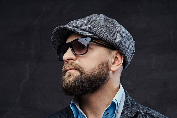 Close-up portrait of a successful stylish man in sunglasses wearing a beret and jacket, isolated on white background - Foto, afbeelding