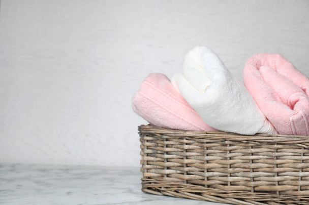 Basket with soft bath towels on table. Space for text - Фото, зображення