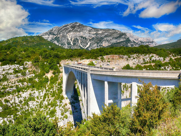 Ponte sul profondo canyon del Verdon nelle Alpi francesi. Qui sotto scorre il fiume Verdon, ci sono montagne e cielo azzurro. Si trova in Francia in Europa
. - Foto, immagini