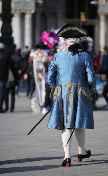 hombre enmascarado con peluca blanca y elegante vestido noble veneciano azul en Piazza San Marco durante el Carnaval de Venecia
 - Foto, Imagen