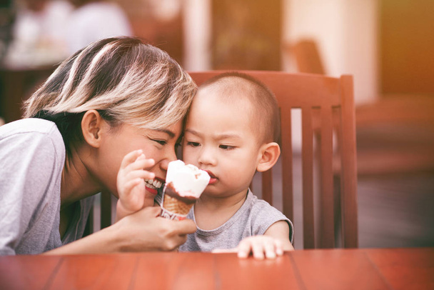 Εικόνες της Ασίας γυναίκες που τρώει παγωτό με το γιο της σε μια ευτυχή διάθεση. Επικεντρώνονται στο πρόσωπο της μητέρας. - Φωτογραφία, εικόνα