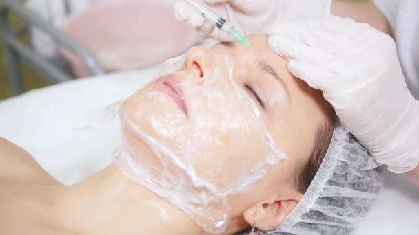 Mesoterapia. Cosmetólogo haciendo procedimiento cosmético de la cara haciendo inyecciones en la frente de los clientes en la clínica de cosmetología
. - Metraje, vídeo