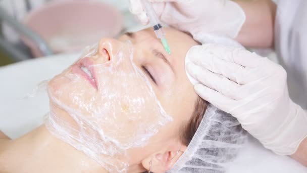 Mesotherapie. Kosmetikerin, die kosmetische Eingriffe des Gesichts vornimmt, Injektionen in die Stirn des Klienten macht und mit ihr in der Klinik für Kosmetik spricht. Gesichtsbehandlung. Kosmetikmaske. Hautpflege. - Filmmaterial, Video