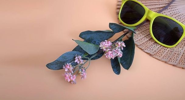Aberto esculpido ventilador tradicional de madeira, flores e vidro solar isolado em fundo rosa simples
 - Foto, Imagem