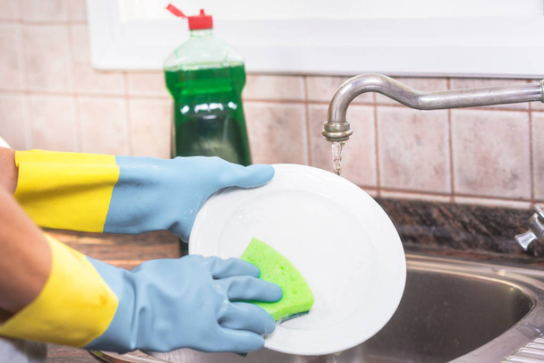Дружина будинку миє посуд на кухні
. - Фото, зображення