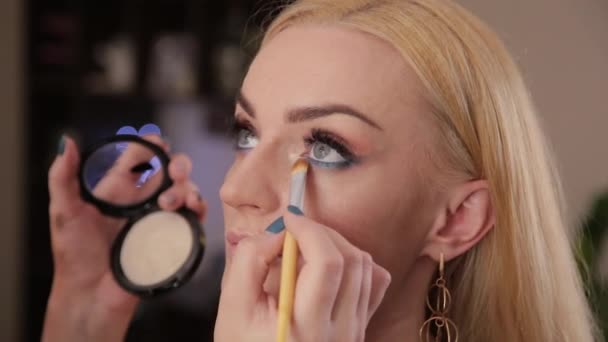 Professional makeup artist makes makeup a very beautiful woman. - Footage, Video
