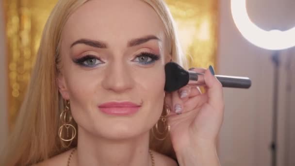 Professional makeup artist makes makeup a very beautiful woman. - Footage, Video