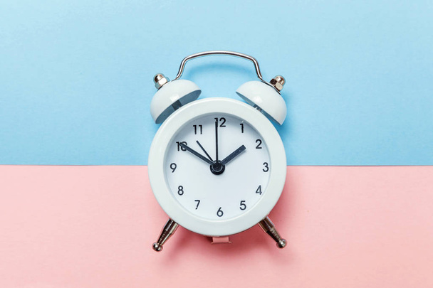 Ringing twin bell vintage classic alarm clock Isolated on blue pink pastel colorful trendy background. Rest hours time of life good morning night wake up awake concept. Flat lay top view copy space - Fotó, kép