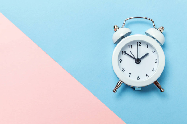 Ringing twin bell vintage classic alarm clock Isolated on blue pink pastel colorful trendy background. Rest hours time of life good morning night wake up awake concept. Flat lay top view copy space - Φωτογραφία, εικόνα