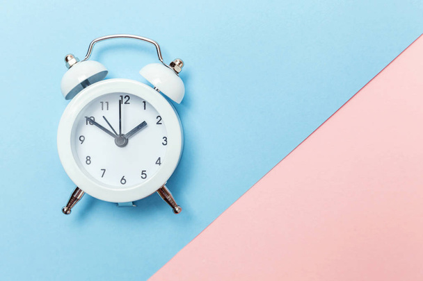 Ringing twin bell vintage classic alarm clock Isolated on blue pink pastel colorful trendy background. Rest hours time of life good morning night wake up awake concept. Flat lay top view copy space - Foto, Imagen