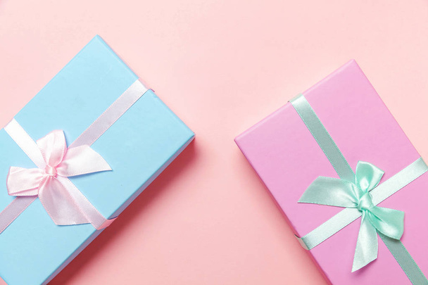 Christmas New Year birthday valentine celebration present romantic concept. Small gift box wrapped pink and blue paper isolated on pink pastel colorful trendy background. Flat lay top view copy space - Photo, Image