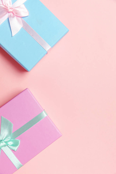Christmas New Year birthday valentine celebration present romantic concept. Small gift box wrapped pink and blue paper isolated on pink pastel colorful trendy background. Flat lay top view copy space - Photo, Image