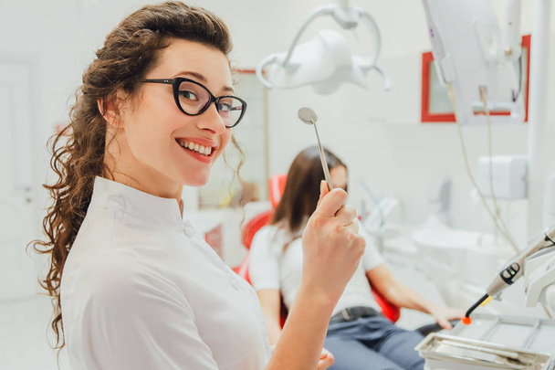 Een aantrekkelijk meisje in een review bij een tandarts. Mooi meisje haar mond opent zit op een tandheelkundige fauteuil. - Foto, afbeelding