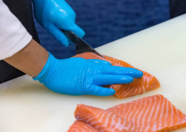 chef tranchant du saumon frais cru, chef préparant un saumon frais sur une planche à découper
 - Photo, image
