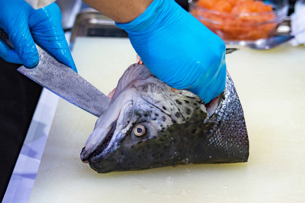 chef slicing raw fresh salmon, Chef preparing a fresh salmon on a cutting board - Photo, Image