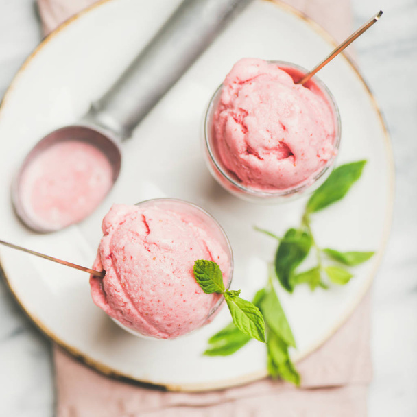 Healthy low calorie summer dessert. Homemade strawberry yogurt ice cream with fresh mint in glasses over light grey marble table background, top view, square crop. Clean eating, dieting food concept - Φωτογραφία, εικόνα