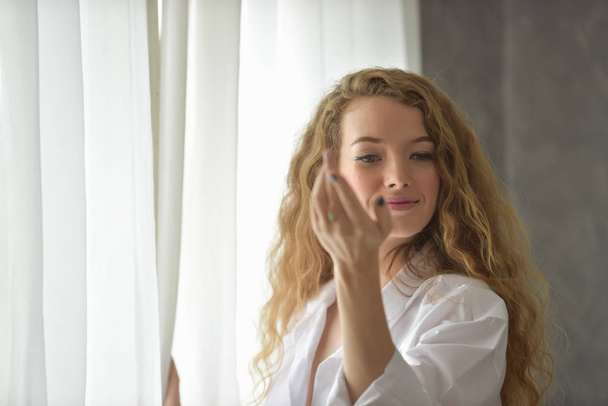 portrét mladé sexy krásná a šťastná žena. Akt ženy s gesty, když ona se probudí ráno v bílým pyžamu. - Fotografie, Obrázek