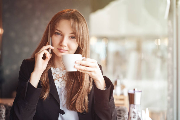 Young business woman talking on the phone in coffee shop. - Photo, image
