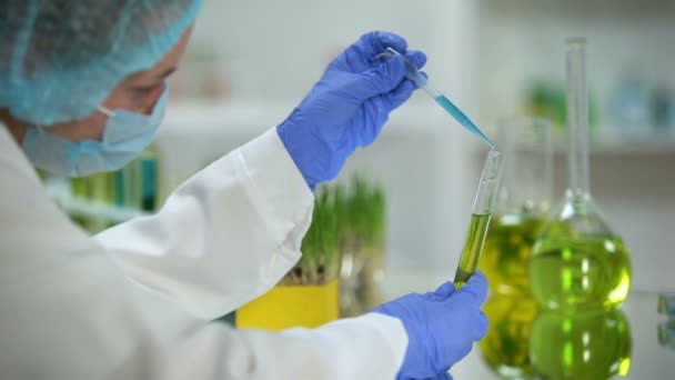 Researcher dripping blue liquid in tube with yellow substance, organic oil test - Πλάνα, βίντεο