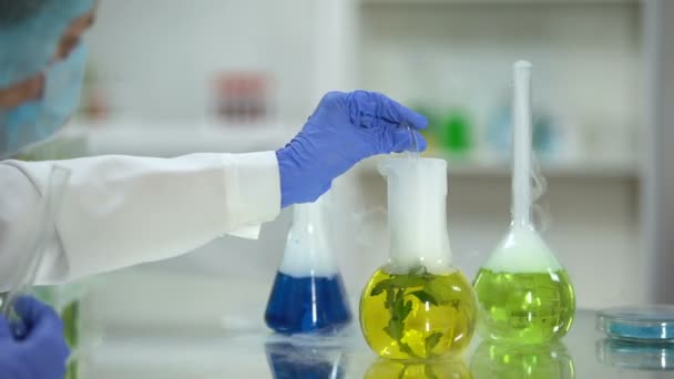 Químico tomando muestra líquida orgánica de frasco con planta, extracto de dermatología
 - Imágenes, Vídeo