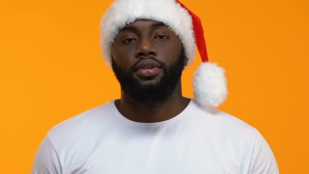 Happy black male in santa hat showing red present box, holidays shopping, sale - Кадры, видео