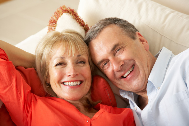 Senior Couple Relaxing On Sofa At Home - Foto, Imagen